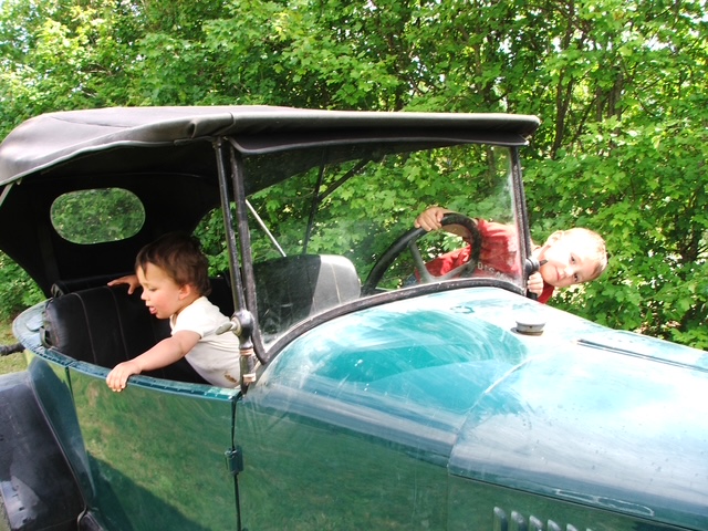 Robin et Justin enfants au volant d'une voiture ancienne restaurée